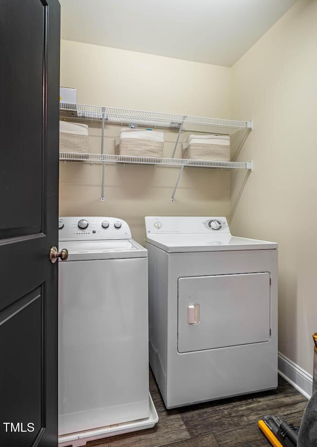 laundry area with washing machine and dryer and dark wood-type flooring