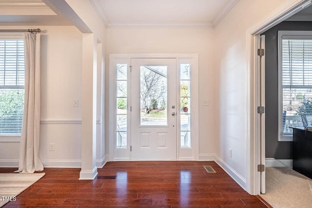 entrance foyer featuring ornamental molding, plenty of natural light, and dark hardwood / wood-style flooring