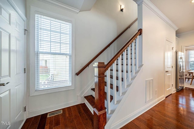 staircase with crown molding and wood-type flooring