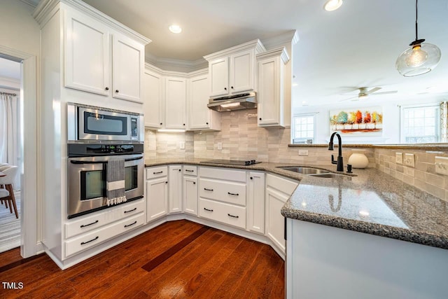 kitchen featuring appliances with stainless steel finishes, kitchen peninsula, sink, and white cabinets