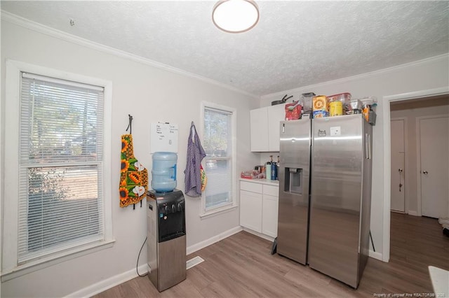 kitchen with white cabinetry, stainless steel fridge, light hardwood / wood-style flooring, and a textured ceiling