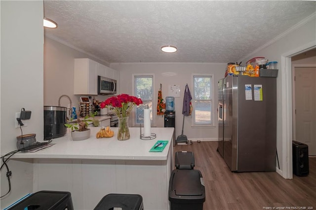 kitchen featuring white cabinetry, light hardwood / wood-style floors, stainless steel appliances, and kitchen peninsula