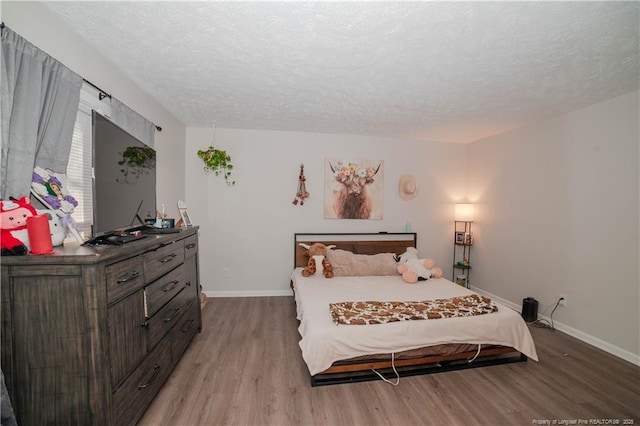 bedroom featuring a textured ceiling and light hardwood / wood-style floors