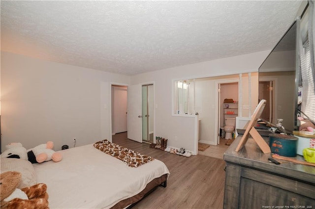 bedroom with wood-type flooring and a textured ceiling