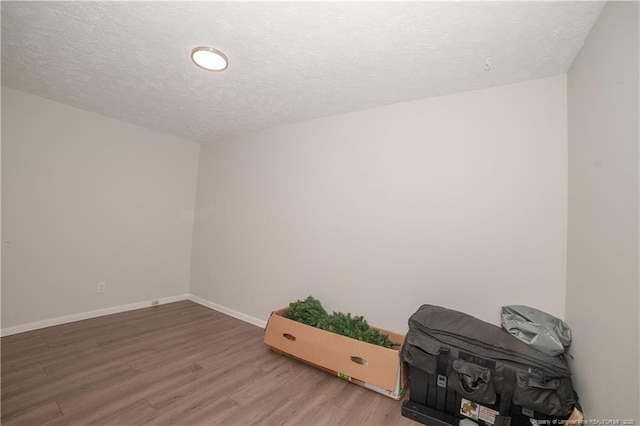 unfurnished room featuring hardwood / wood-style floors and a textured ceiling