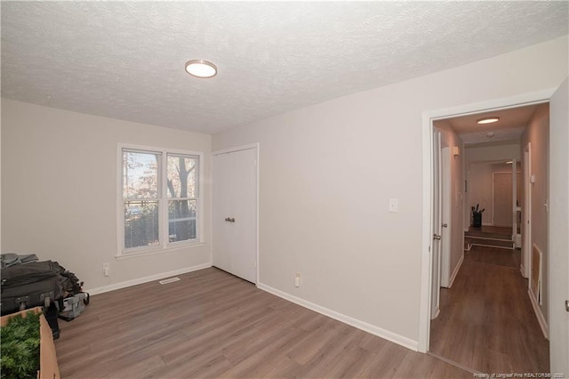 empty room featuring hardwood / wood-style floors and a textured ceiling