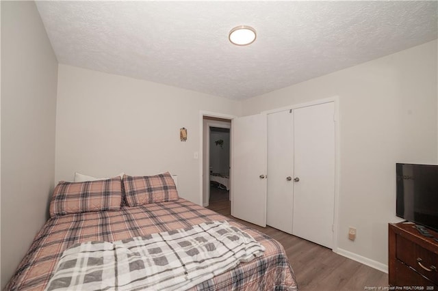 bedroom featuring hardwood / wood-style floors, a textured ceiling, and a closet