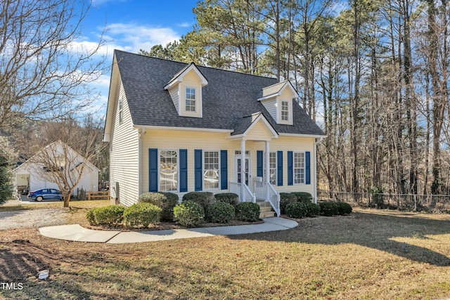 cape cod house with a front yard