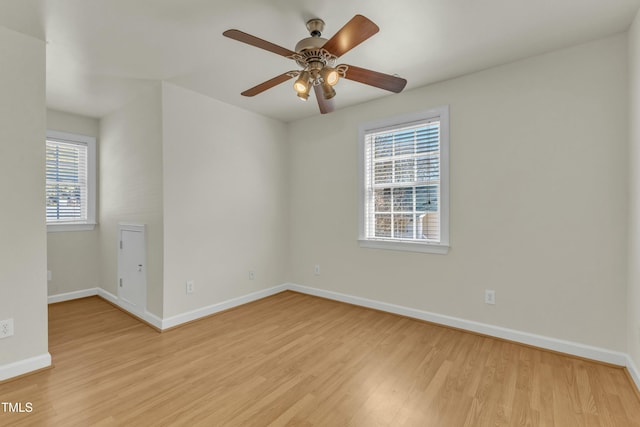 unfurnished room featuring ceiling fan, a wealth of natural light, and light wood-type flooring