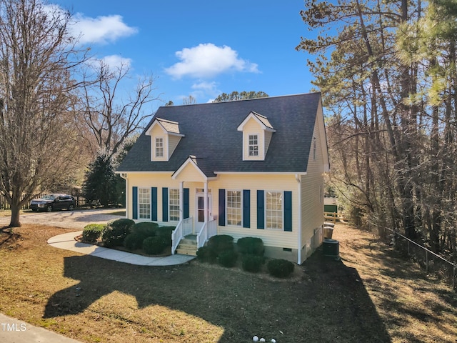 cape cod-style house featuring cooling unit and a front lawn