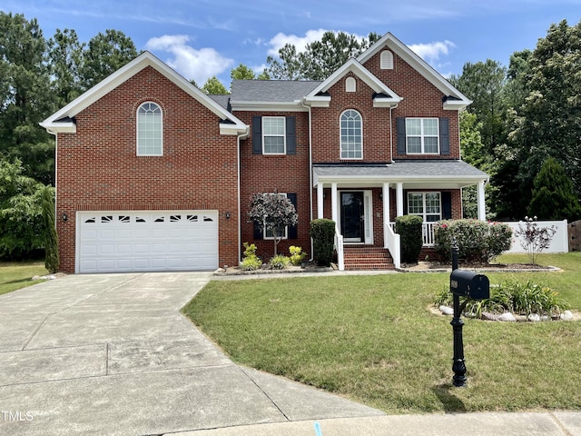 view of front of home featuring a garage, covered porch, and a front lawn