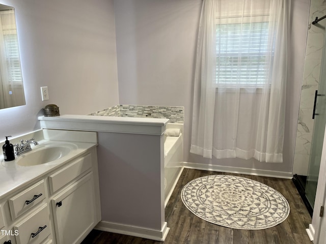 bathroom with hardwood / wood-style flooring, vanity, and shower with separate bathtub