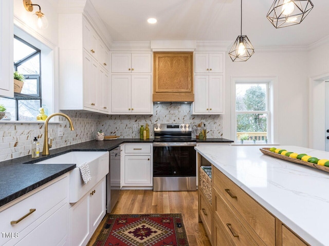 kitchen with sink, light stone counters, decorative light fixtures, appliances with stainless steel finishes, and white cabinets