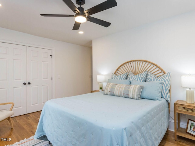 bedroom featuring hardwood / wood-style floors, ceiling fan, and a closet