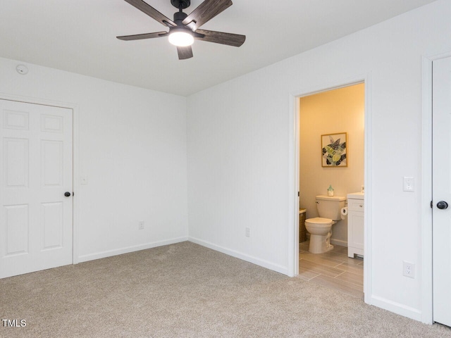 unfurnished bedroom featuring light carpet and ensuite bath