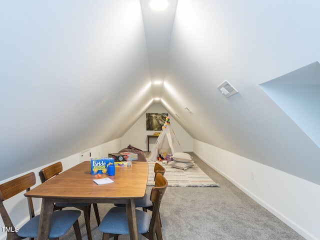 carpeted dining space featuring lofted ceiling