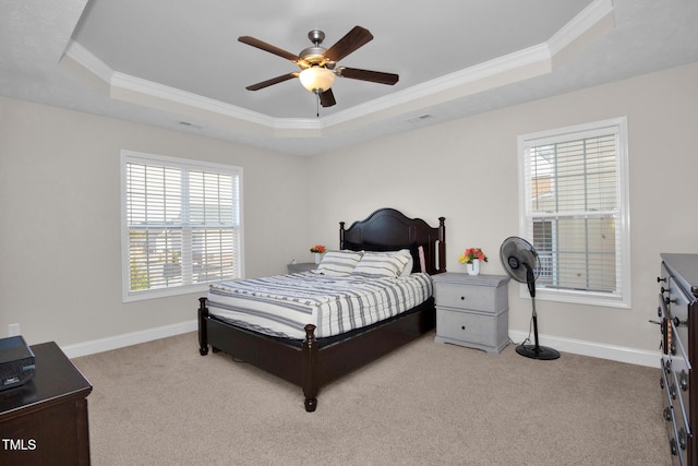 bedroom featuring a raised ceiling, ornamental molding, and light carpet