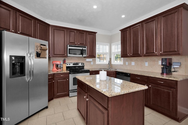 kitchen featuring sink, decorative backsplash, ornamental molding, a center island, and stainless steel appliances