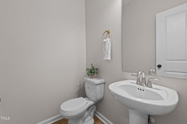 bathroom with sink, hardwood / wood-style floors, and toilet