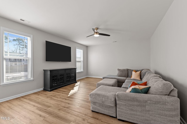 living room featuring ceiling fan, plenty of natural light, and light hardwood / wood-style flooring