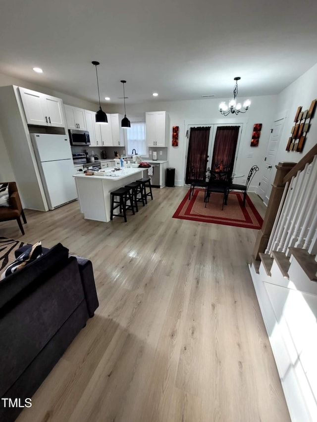 living room with a chandelier and light hardwood / wood-style floors