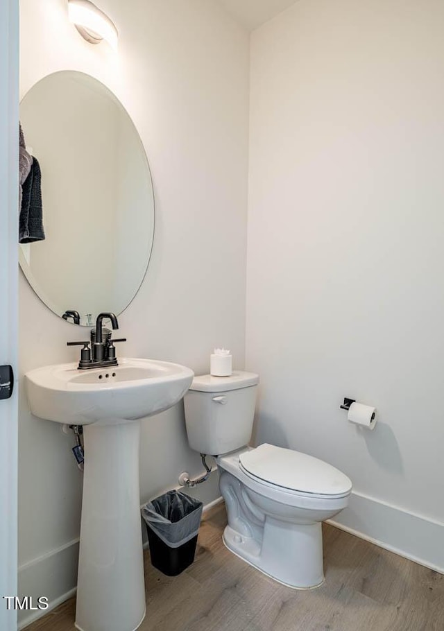 bathroom featuring wood-type flooring and toilet