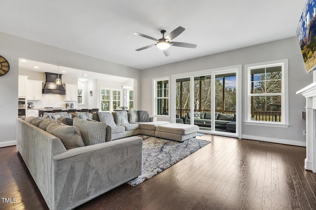 living room featuring ceiling fan, dark hardwood / wood-style floors, and a fireplace