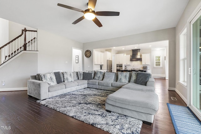 living room with ceiling fan and dark hardwood / wood-style flooring