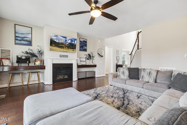 living room with dark wood-type flooring and ceiling fan