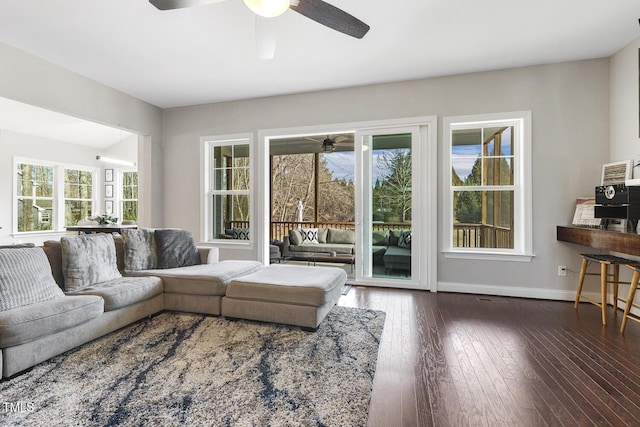 living room with dark wood-type flooring and ceiling fan