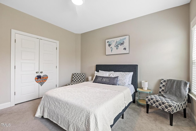 bedroom featuring light colored carpet and a closet