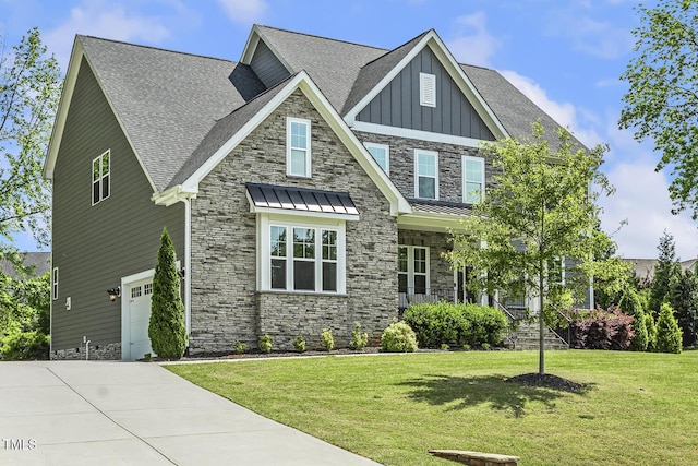 craftsman-style home featuring a front lawn, board and batten siding, driveway, stone siding, and a garage