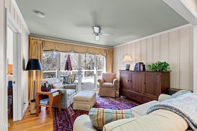 living room with crown molding, wood-type flooring, and ceiling fan