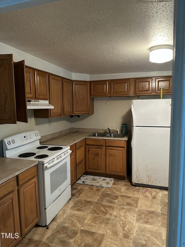 kitchen with sink, a textured ceiling, and white appliances