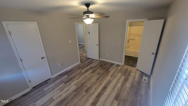 unfurnished bedroom featuring hardwood / wood-style flooring, ceiling fan, and ensuite bath