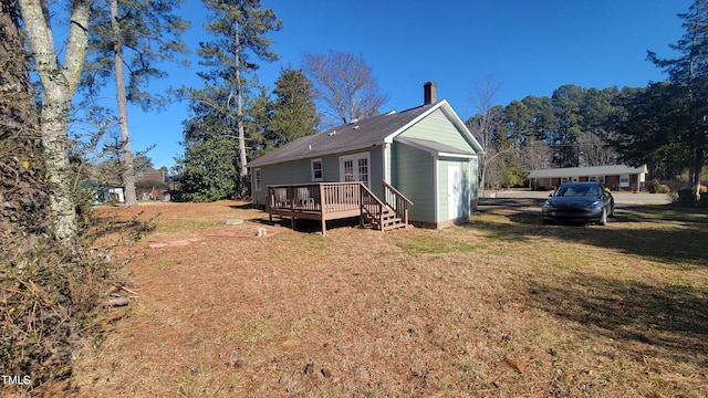 rear view of property featuring a yard and a deck