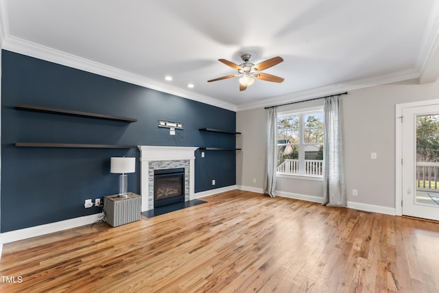 unfurnished living room with hardwood / wood-style floors, crown molding, a fireplace, and plenty of natural light