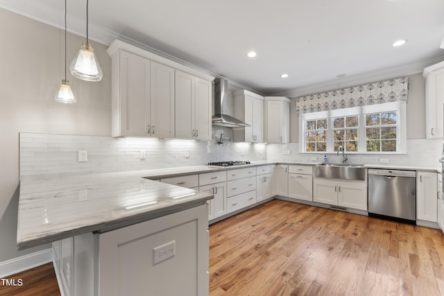 kitchen with wall chimney exhaust hood, stainless steel appliances, sink, and white cabinets