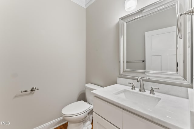 bathroom with crown molding, vanity, and toilet