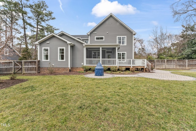 rear view of house with a lawn, a sunroom, a patio, and a deck