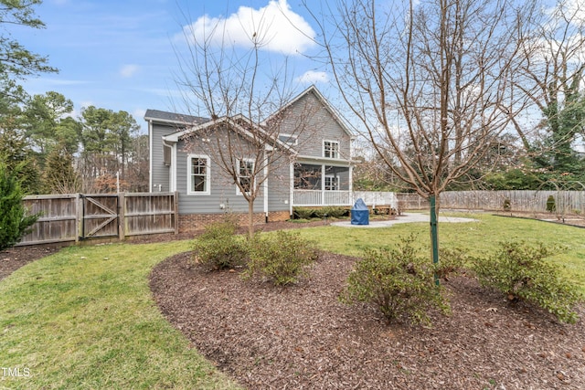 back of house featuring a yard and a sunroom