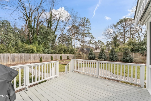 wooden deck featuring a grill and a yard