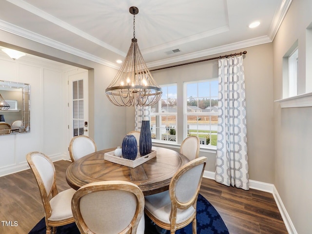 dining area featuring ornamental molding, dark hardwood / wood-style flooring, a raised ceiling, and a notable chandelier