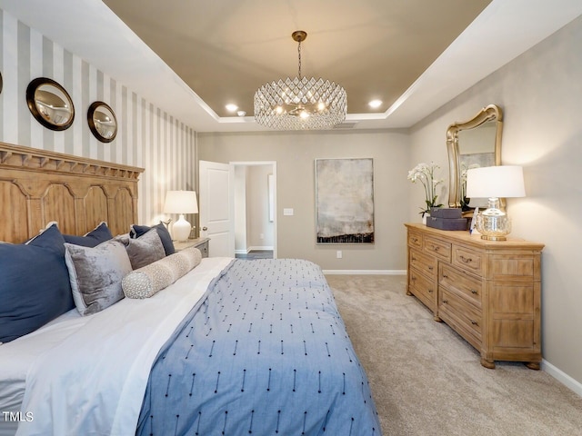 bedroom with an inviting chandelier, light colored carpet, and a raised ceiling