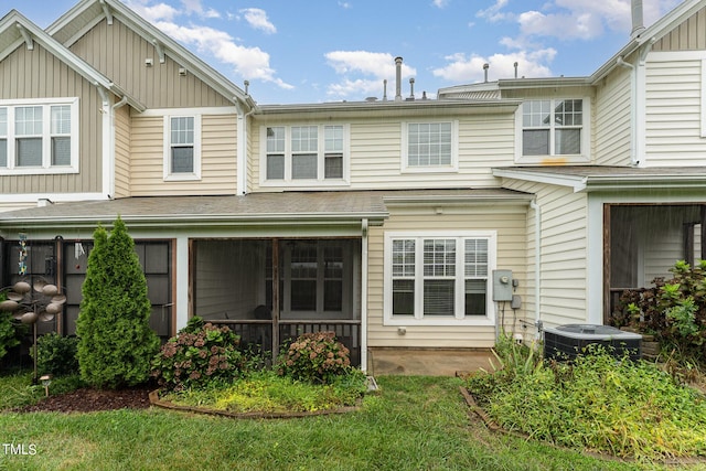 rear view of property featuring central AC and a lawn