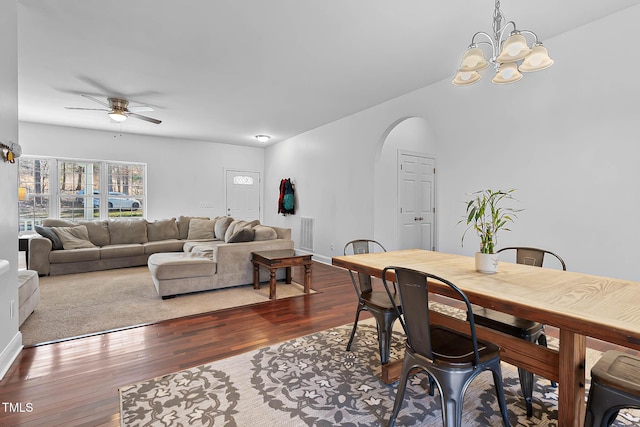 dining area with dark hardwood / wood-style flooring and ceiling fan with notable chandelier