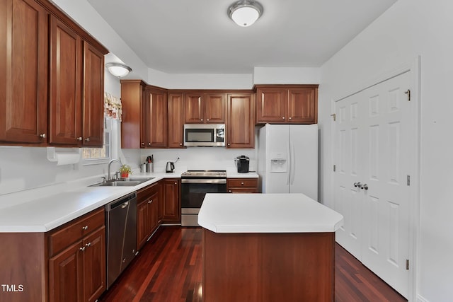 kitchen with dark wood-type flooring, appliances with stainless steel finishes, sink, and a kitchen island