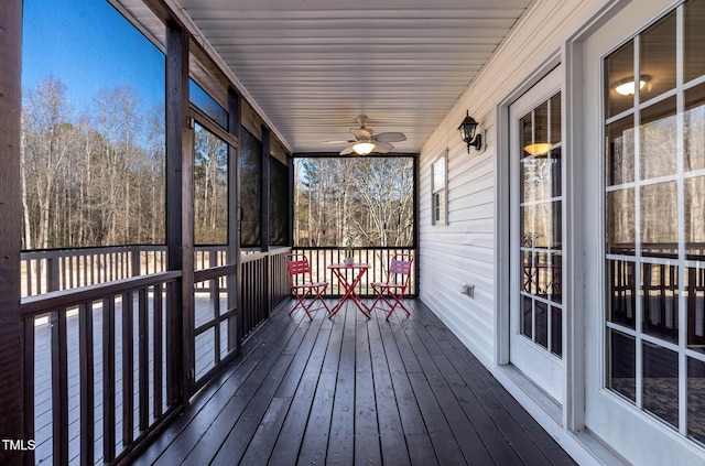 unfurnished sunroom featuring ceiling fan