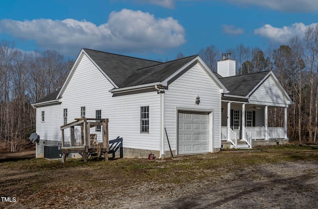 rear view of property with a garage and a porch