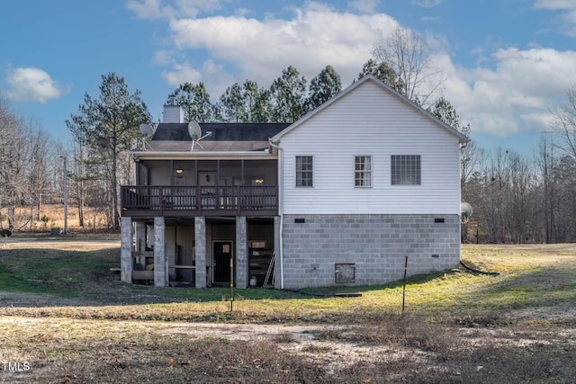 back of property with a sunroom and a yard